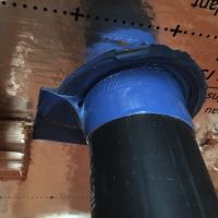 Détail d'étanchéité à l'air autour d'un évent de plomberie vert le toit. C'est un genre de bande collante élastique très malléable épousant facilement des pourtours de ces tuyaux ou de fils sortant vers l'extérieur (référence : Ampacoll BK535)