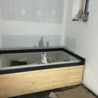 baignoire avec le tablier de bois et l'ardoise autour.