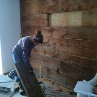 Réparation d'un trou dans le mur en bois de la chambre d'amis.